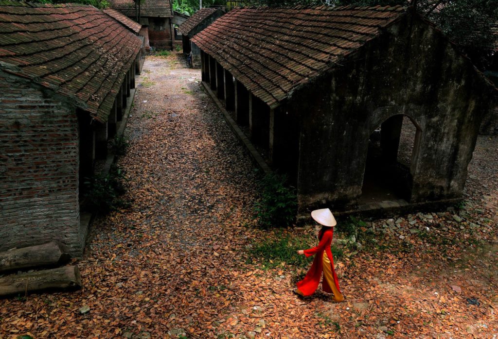 A woman walking in a rural Chinese village in the fall