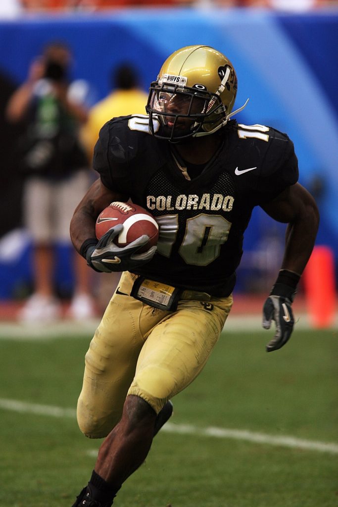 A football player for the Colorado Buffaloes running with the ball.
