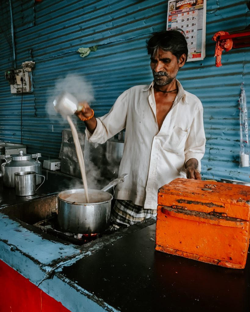 Chai being poured by into a pot by a man in India