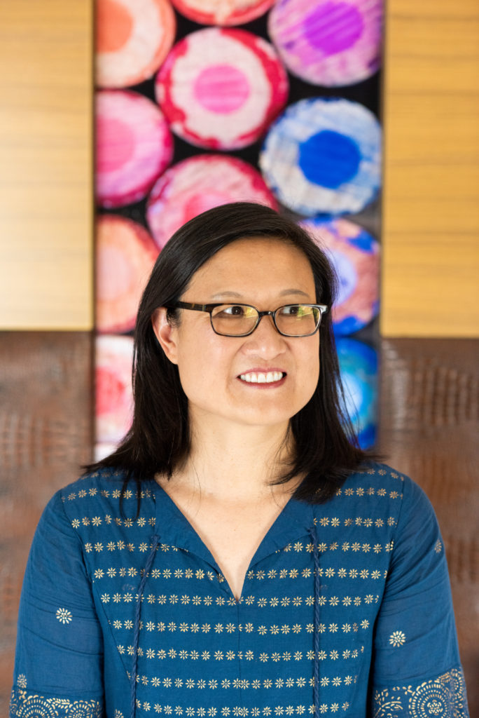 University of Colorado ethnic studies professor and director of the Center for Humanities & the Arts Jennifer Ho standing in front of a colorful painting