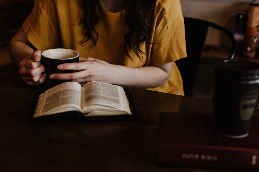 A woman drinking tea and reading a book