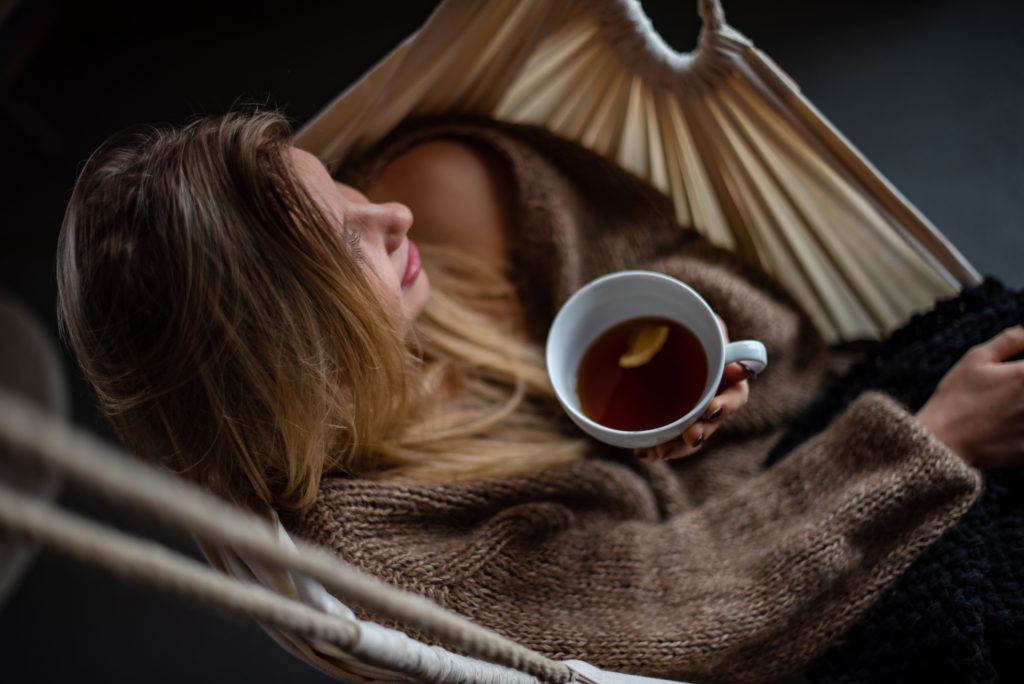 A woman relaxing with tea on a hammock